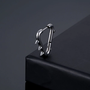 Punk style stainless steel triangle hoop earring with sharp rivets on a dark display stand