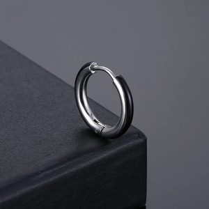 Boucle d'oreille créole en acier inoxydable poli argent et noir sur une boîte à bijoux