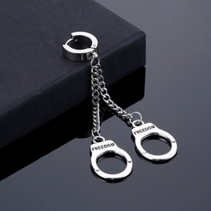 Detailed close-up of silver steel tassel earrings with FREEDOM handcuff charms