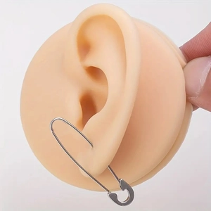 Minimalist stainless steel safety pin earrings shown on a silicone ear model display