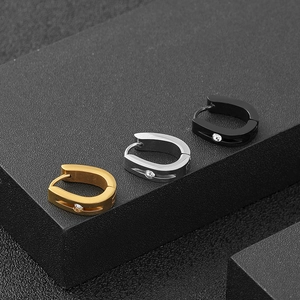 Dettaglio di orecchini a cerchio a U in acciaio inossidabile in oro, argento e nero con zircone