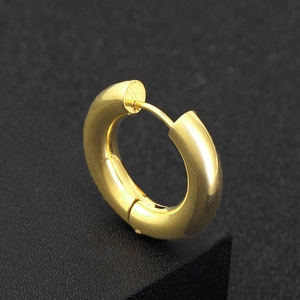 Boucle d'oreille créole épaisse en acier inoxydable doré sur fond noir texturé