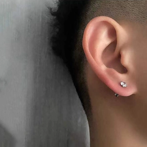 Titanium steel stud earrings with round-cut zircon on earlobe shown in a close-up view
