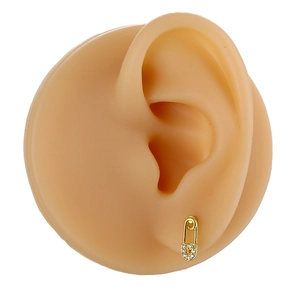 Detail view of a gold safety pin earring featuring micro-pave cubic zirconia on an ear model