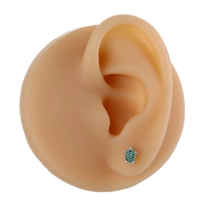 Micro-set silver turtle stud earring with green crystals on a silicone ear model