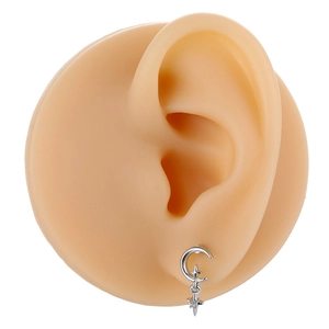Detail of silver crescent moon and cross star earrings with zircon on a silicone ear model