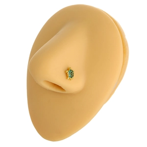 Macro shot of 20G gold turtle nose stud with green zircon inlay on a silicone model