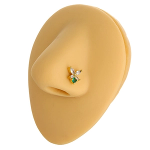 Close-up of golden butterfly nose stud with white marquise and green zircon on a model