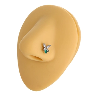 Detailed view of butterfly nose stud with green and white zircons on a model