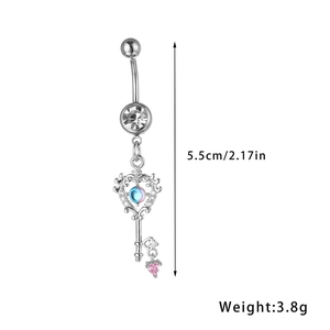 Detail van een sleutelvormige navelring met blauwe stenen en roze hartvormige hanger