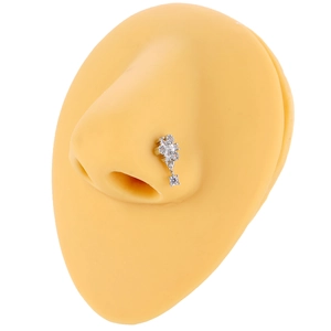 Flower shaped copper nose ring with zircon stones shown on a silicone model nose