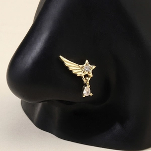 Golden star nose ring with crystal wing and teardrop charm on a nose model