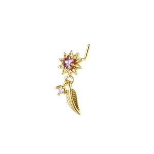 Macro shot of L-shaped gold nose stud featuring a purple star gemstone and feather charm