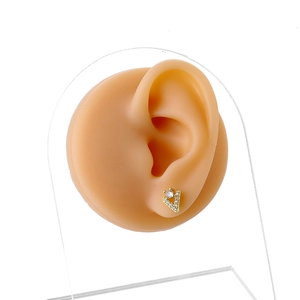 Elegant gold V-shaped stud earring with micro-paved zircons on a silicone ear model