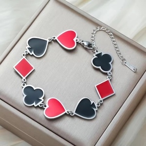 Gold-plated stainless steel poker suit charm bracelet featuring enamel heart and spade shapes