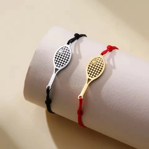 Detailansicht der gewebten Tennisracket-Armbänder in Schwarz und Rot mit Metallanhängern