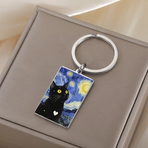 Detailed close-up of a stainless steel keychain with a Van Gogh style Starry Night cat print