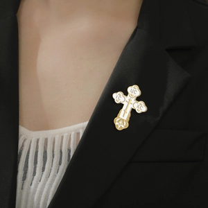 Golden Orthodox cross brooch with white enamel detail on black suit lapel pin