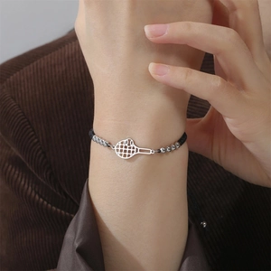 Detail eines minimalistischen Tennisracket-Armbands mit Silberperlen auf schwarzer Kordel