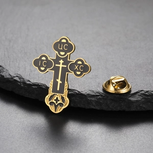 Detail of Orthodox cross brooch in gold and black enamel with classic religious symbols