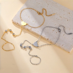 Detail of gold and silver heart charm ring bracelets with zircon stones and adjustable chain