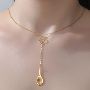 Elegante collana a Y con racchetta da tennis dorata indossata da una modella in dettaglio