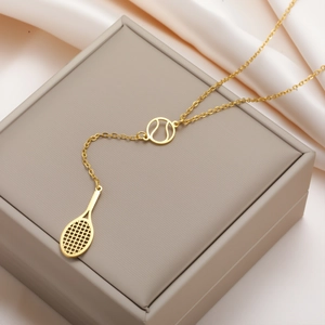 Dettaglio della collana con ciondolo a racchetta da tennis dorata su scatola regalo