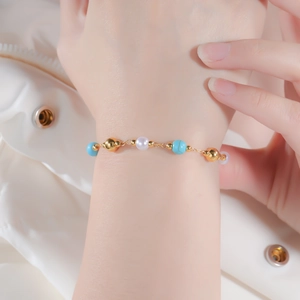 Close-up of bohemian gold bracelet featuring blue turquoise beads and white pearls