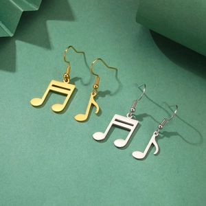 Vista macro de pendientes asimétricos de nota musical en acabado pulido oro y plata