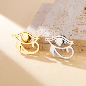 Detailed view of gold and silver Eye of Horus pins on stone with shadow details