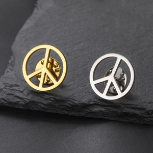 Detail of vintage peace symbol pins in gold and silver finish with butterfly clutch backings