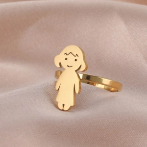 Close-up of golden stainless steel ring featuring a minimalist girl charm on satin