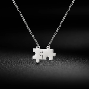 Collana con ciondolo a forma di puzzle argento lucido su una catena in acciaio inossidabile