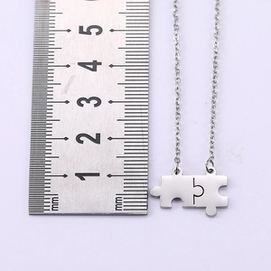 Dettaglio della collana con ciondolo a puzzle argento con misura di 30mm sul righello