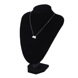 Dettaglio della collana con ciondolo a forma di puzzle su manichino in velluto nero