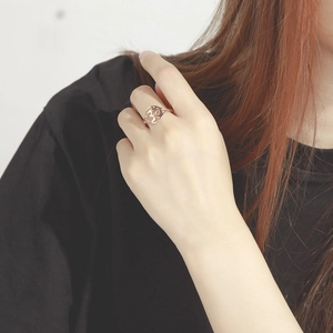 Close-up of rose gold Om symbol open ring worn on finger with minimalist hollow design