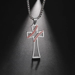 Détail du pendentif croix de baseball argenté avec coutures rouges sur fond noir texturé