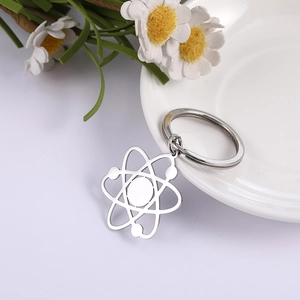 Poliertes Edelstahl-Atom-Schlüsselanhänger auf minimalistischem weißem Hintergrund