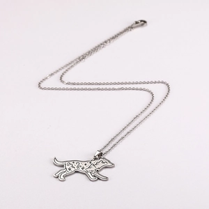 Macro detail of stainless steel wolf pendant with mountain and star engravings