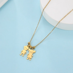 Collana dorata con ciondoli bambino e bambina su sfondo azzurro raffinato