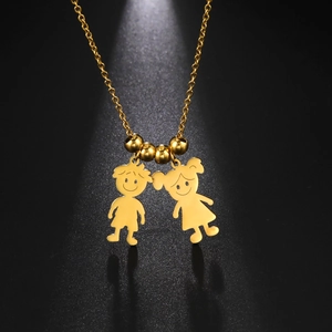 Collana dorata con pendenti a forma di ragazzo e ragazza cartone animato su sfondo nero