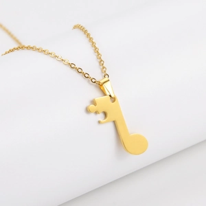 Detailed close-up of golden music note puzzle pendant with polished finish