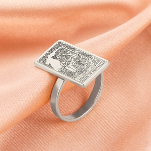 Detalle del anillo de Tarot Reina de Oros plateado sobre tela rosa suave