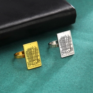 Detail of Ten of Swords tarot card design on rectangular steel ring in gold and silver