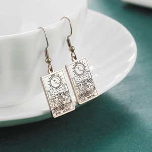Detailed macro view of vintage silver The Moon tarot card earrings with black engraving