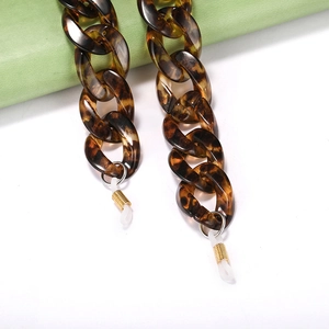 Détails macro des maillons en acrylique écaille avec boucles antidérapantes blanches