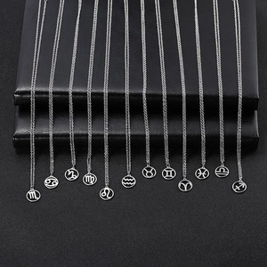 Set of 12 stainless steel necklaces featuring cutout hollow zodiac sign pendants on black display