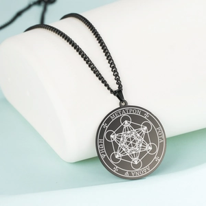 Archangel Metatron cube necklace in black stainless steel on a minimalist display stand