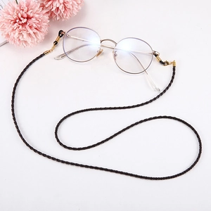 Détail de la lanière tressée pour lunettes marron foncé avec fermoir doré et anneaux silicone