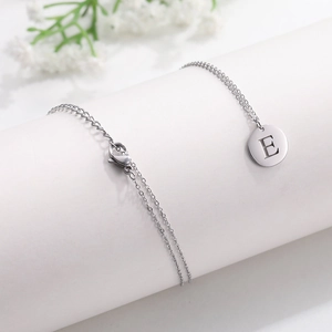 Polished silver stainless steel round pendant necklace with cutout capital letter E
